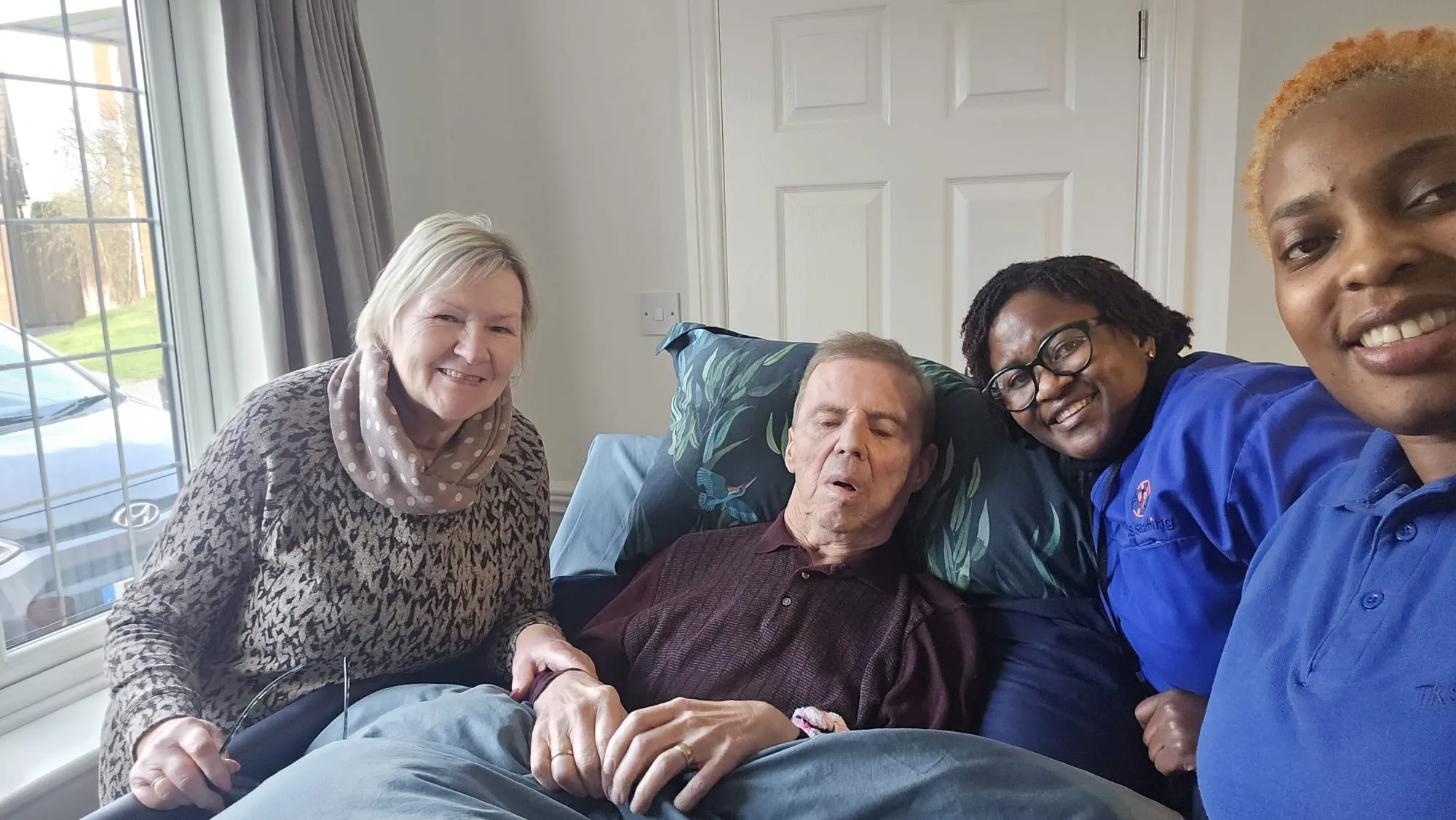 TKS Staffing carers with a client and his family in his living room
